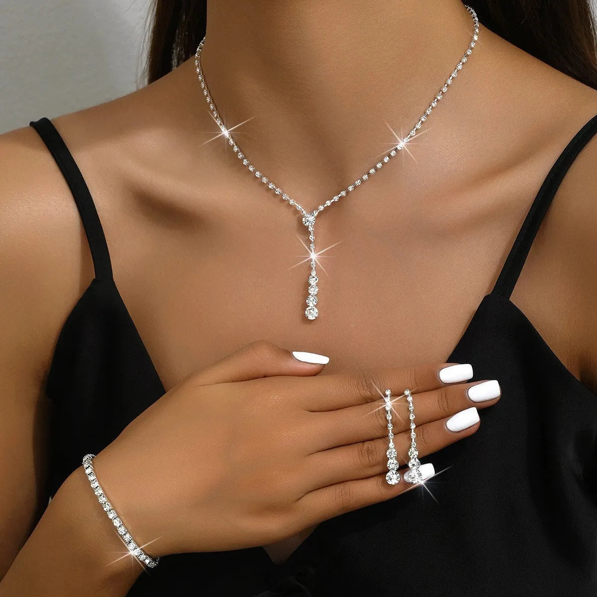 Wedding jewellery three-piece set showing necklace, bracelet and earrings with rhinestone pendants