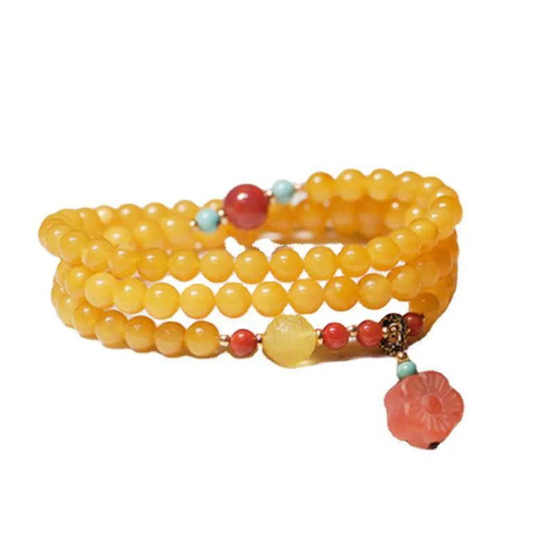 Yellow amber bracelet with 5mm round beads and animal zodiac design on a wrist.