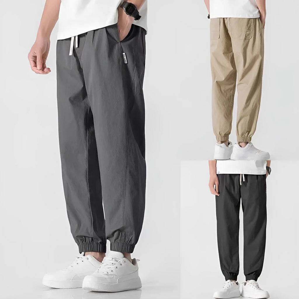Men's loose cuffed cargo pants in black polyester fabric with cuffed hem and relaxed fit