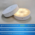 Small white round USB rechargeable motion sensor LED night light with adhesive backing.