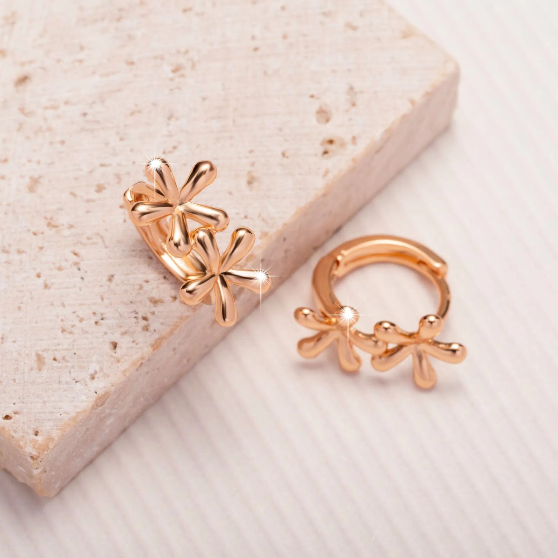 A pair of rose gold circular earrings featuring a waterdrop floral design with a fresh, sweet style.