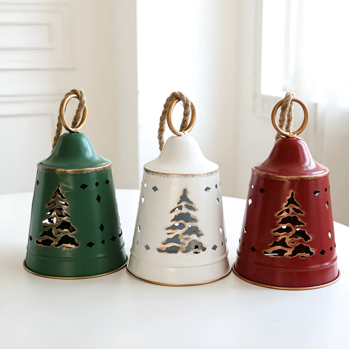 Wrought iron Christmas bell ornament in red, green, and white with hanging loop on a white background
