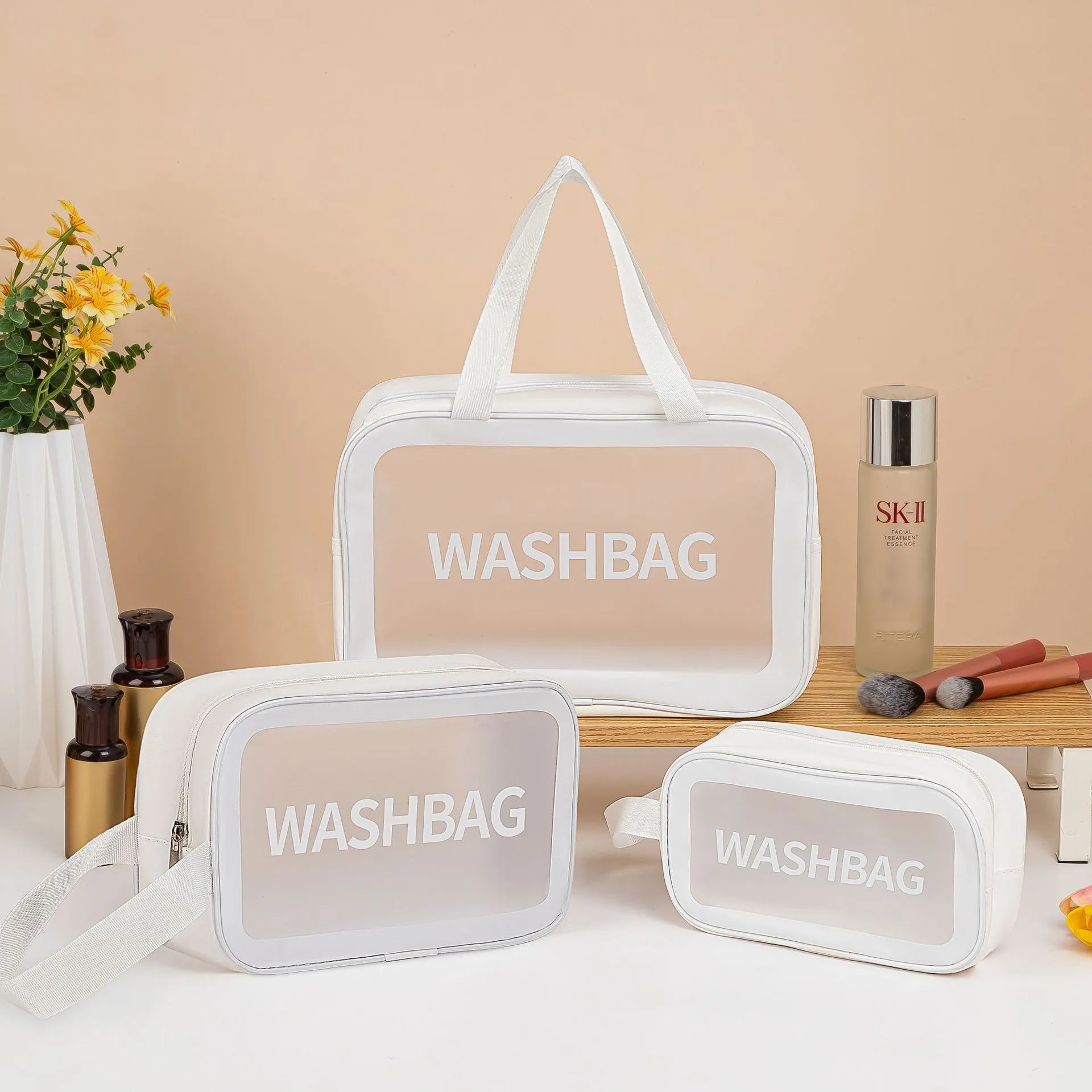 Large PVC transparent cosmetic bag three-piece set in various colours including beige, black, blue, pink, and white, empty and open on a flat surface