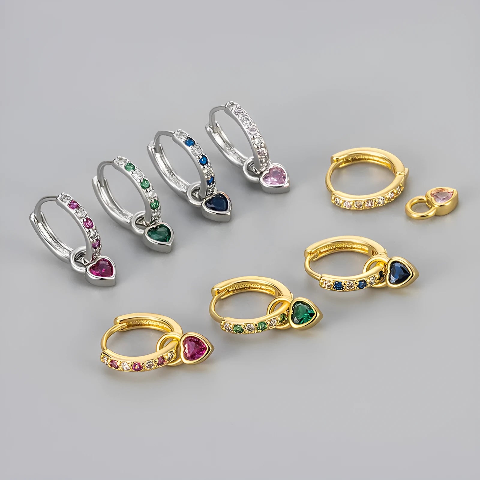 Gold colour heart-shaped clip earring with a central blue zircon stone on a white background.