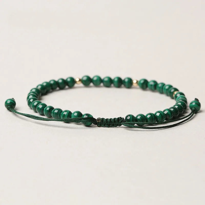 Green malachite stone bracelet with golden beads on woven strap, zodiac animal motif.