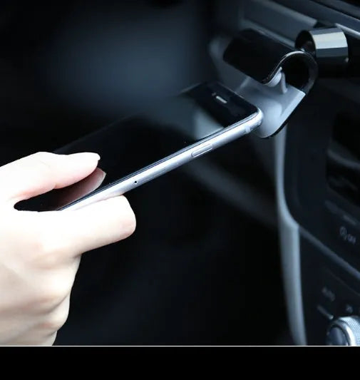 Universal gravity car phone holder with 360-degree rotation, black ABS plastic, mounted on dashboard with phone in portrait mode