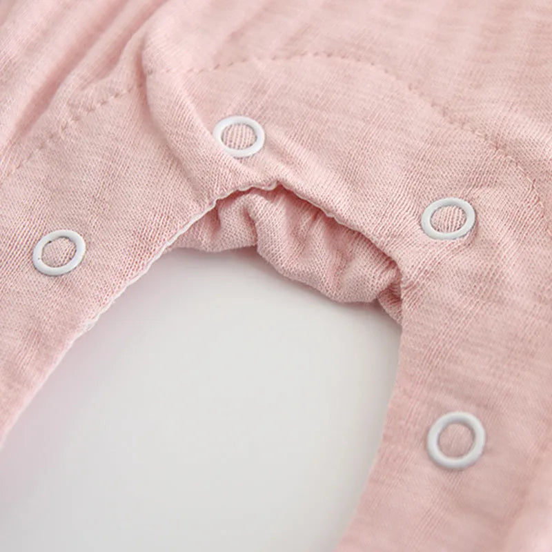 Pink long sleeve cotton baby jumpsuit with single-breasted front closure for a girl.