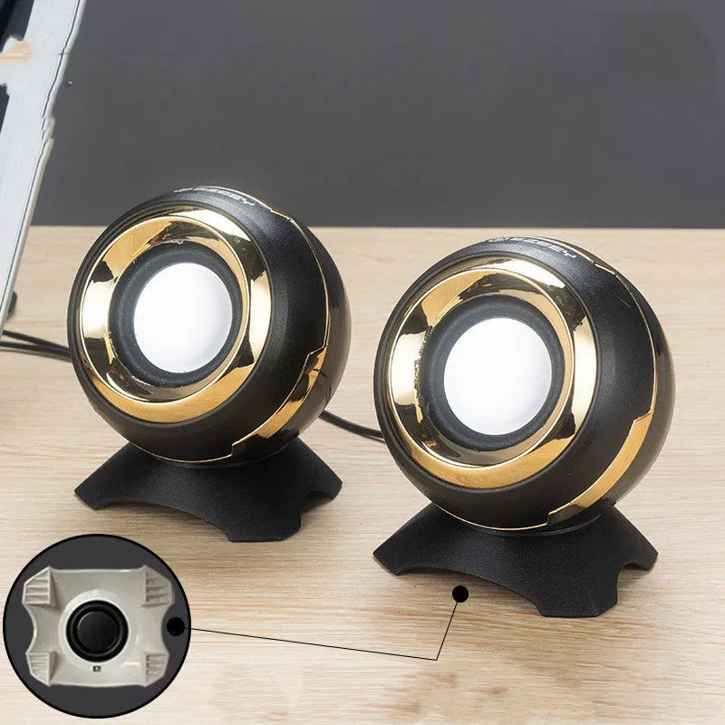 Compact black and gold desktop computer speakers with USB cable