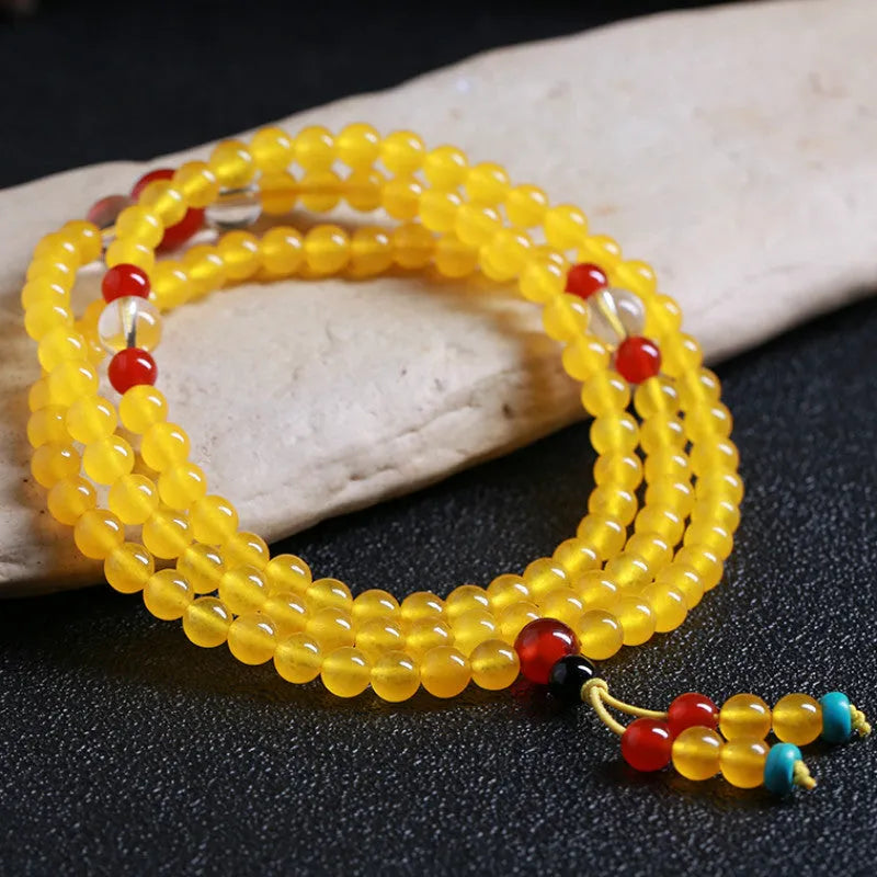 Women's geometric crystal necklace with lucky cat charm alongside 108 agate and canary stone beads