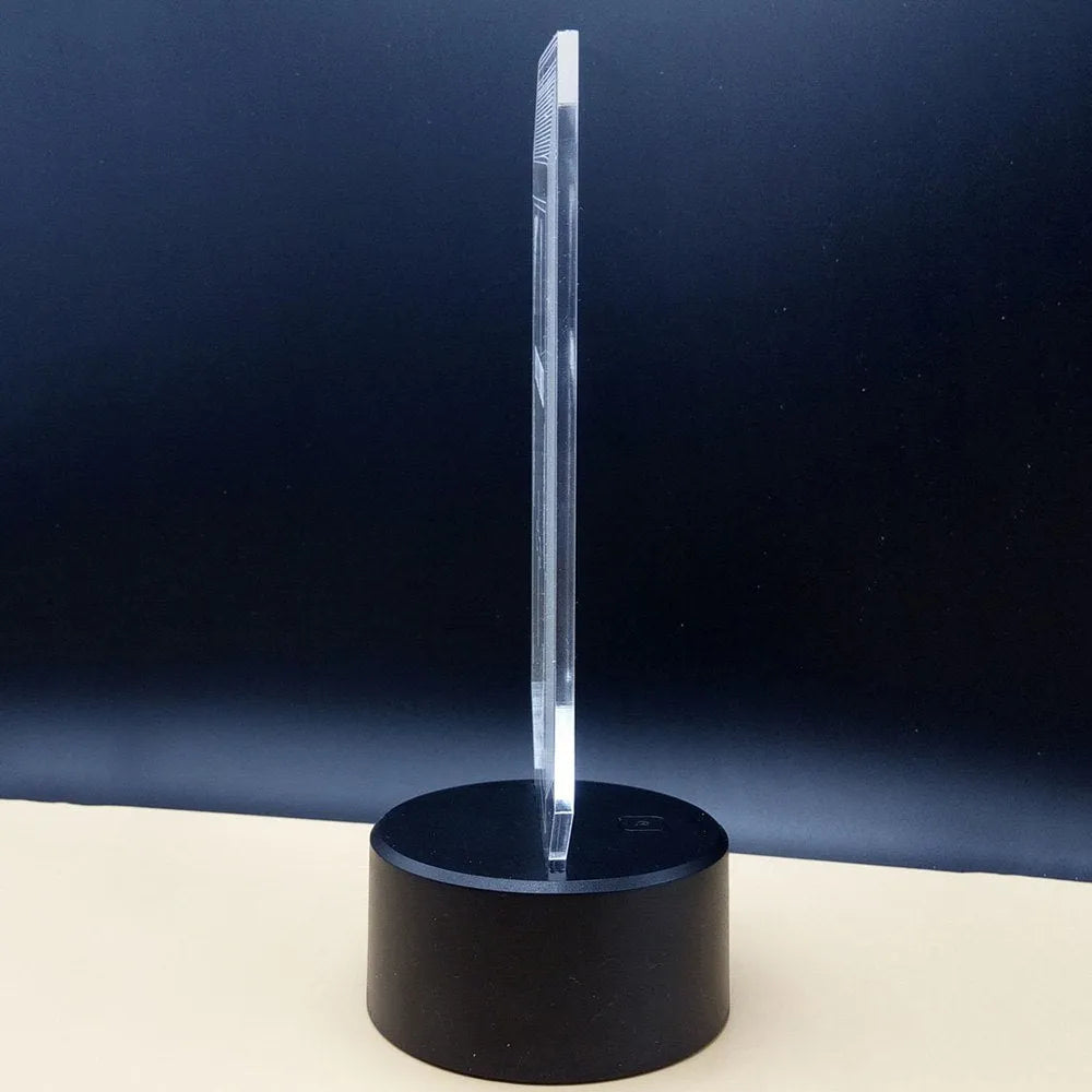 3D acrylic brain hologram LED desk lamp with black base and remote control on a wooden table.