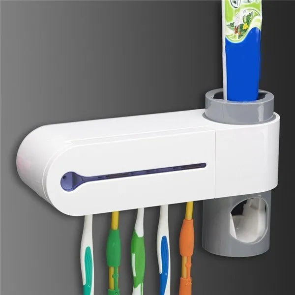 White 3-in-1 toothbrush holder with UV steriliser and toothpaste dispenser, wall-mounted on a bathroom tile