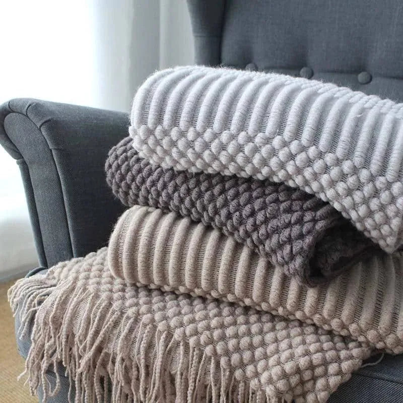Small rectangular nap blanket in a neutral colour, showing its compact size relative to a hand.