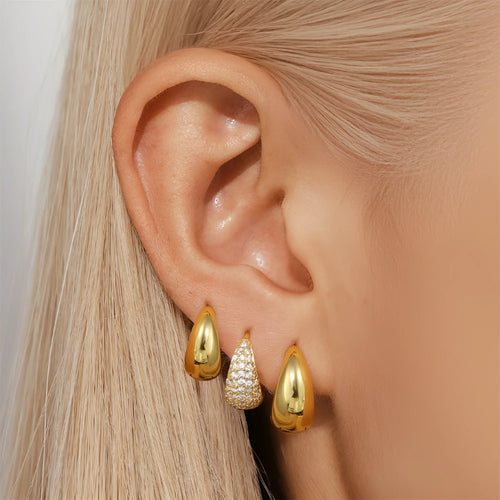 A pair of gold tone geometric earclip earrings with a round design and screw-back mechanism.