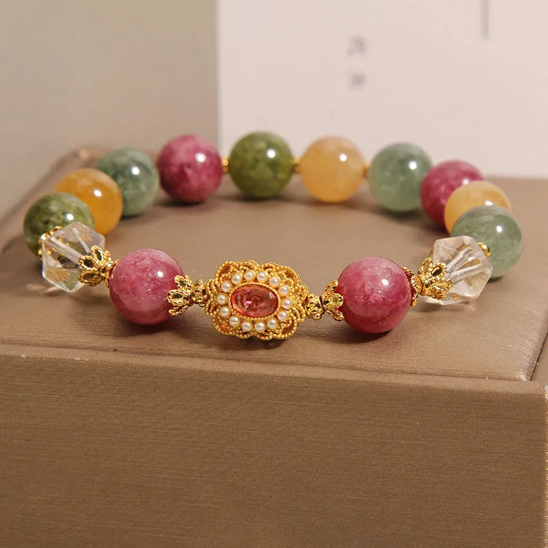 Close-up of a women's bracelet with multicolour tourmaline beads on an alloy band with crystal and rhinestone details.
