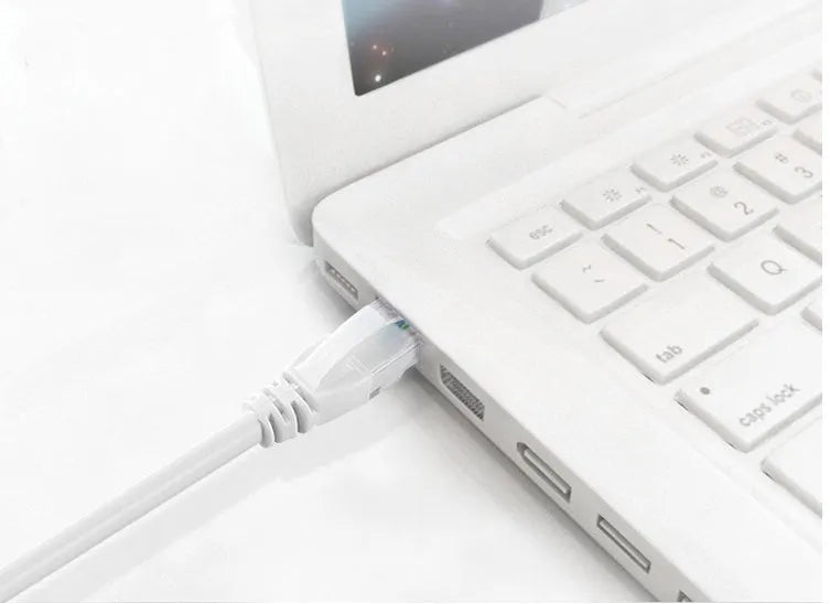 White Cat6 network cable with RJ-45 connectors on both ends lying on a flat surface