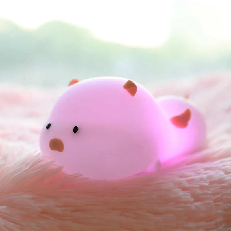 Blue silicone pig-shaped night light with sleeping design and USB charging port