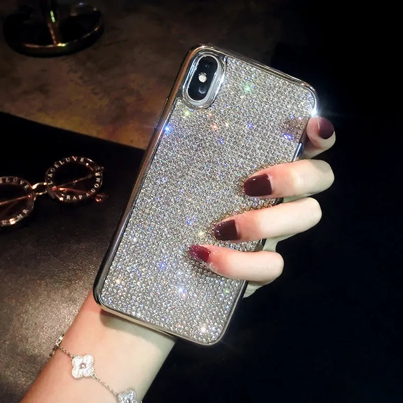 Silver silicone full diamond protective case for iPhone on a table.