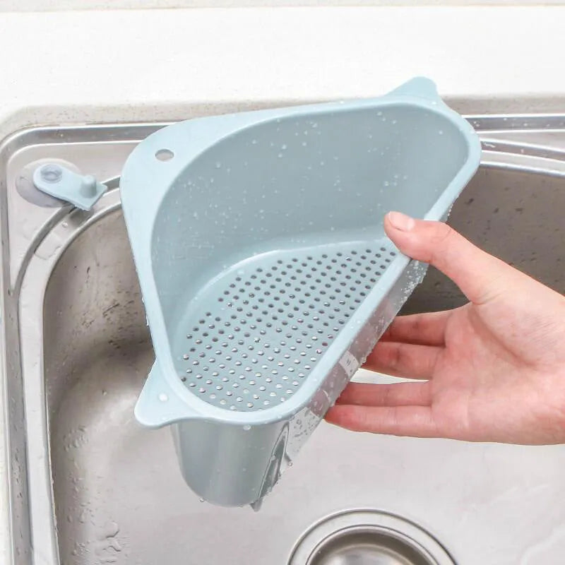 Beige plastic triangle sponge drain rack hanging from a kitchen faucet.