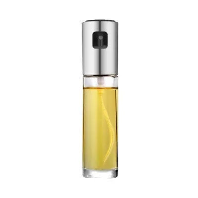 Gold pump-action oil and vinegar spray bottle with 100ml glass body on kitchen counter.