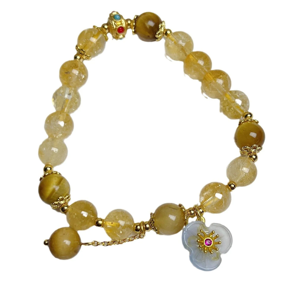 Women's citrine crystal bracelet with gold-plated flower tassel design on wrist.