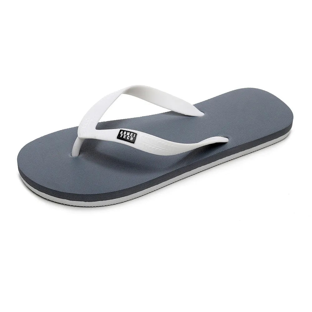 Men's black flip-flops with a textured rubber sole and EVA foam upper on a sandy beach.