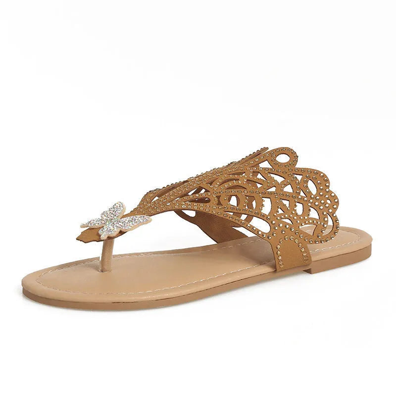 Women's black slip-on sandals with rhinestone details and flip-toe design on a flat rubber sole