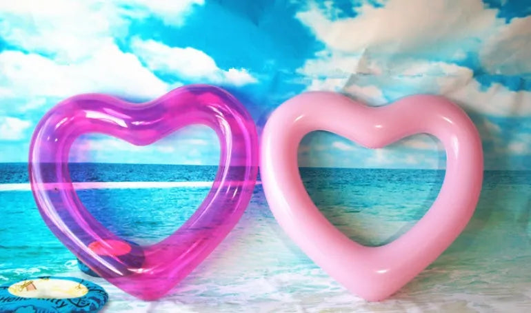 Oversized 120cm heart shaped swim ring in pink floating on water, adult outdoor pool toy