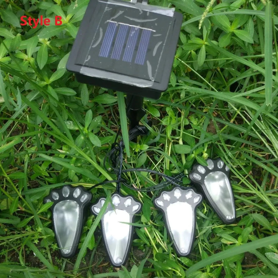 Four black paw print solar garden lights connected to central solar panel pole