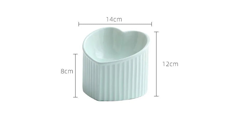 Close-up of a pink ceramic pet bowl with a slanted rim, showing the inclined feeding surface against a clean background.