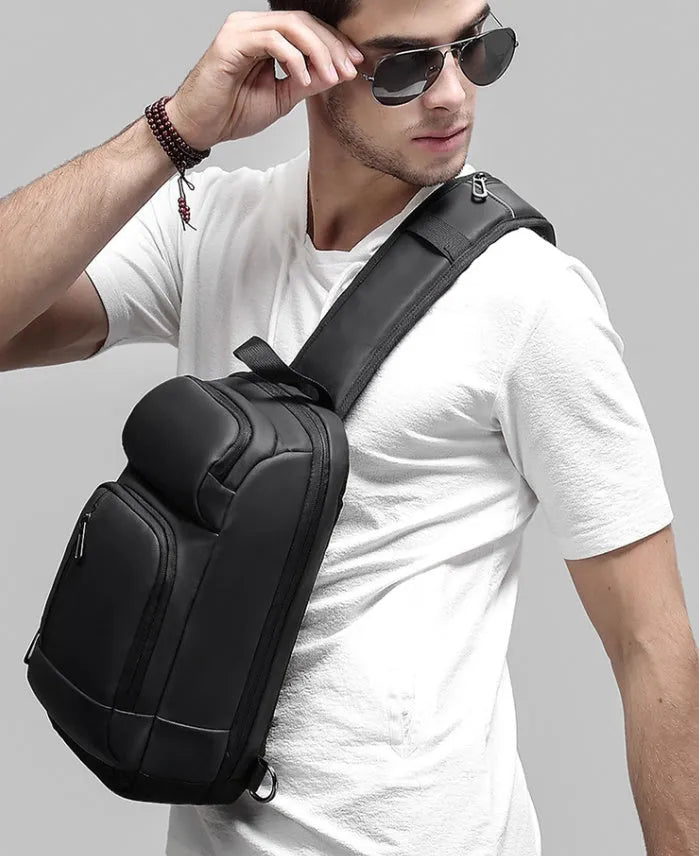 Black PVC outdoor shoulder bag with zipper, internal pockets, and an air cushion shoulder strap.