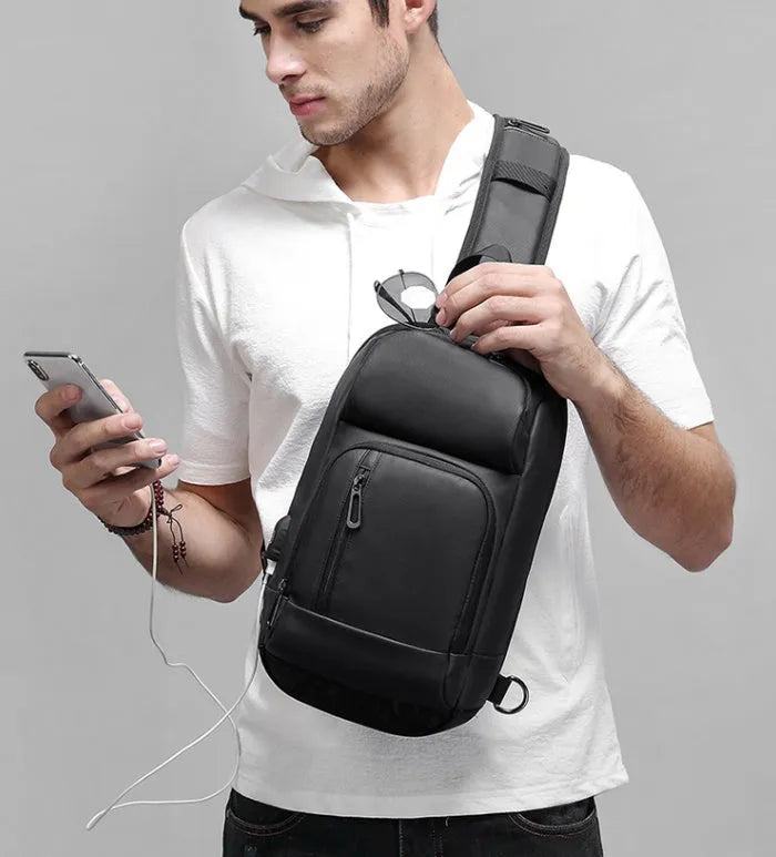 Black PVC outdoor shoulder bag with zipper, internal pockets, and an air cushion shoulder strap.