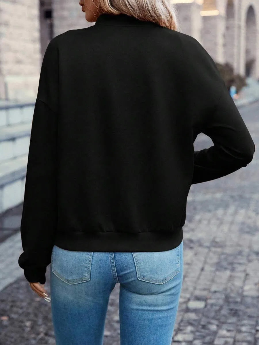 A black women's casual zip-up jacket with long sleeves on a hanger.