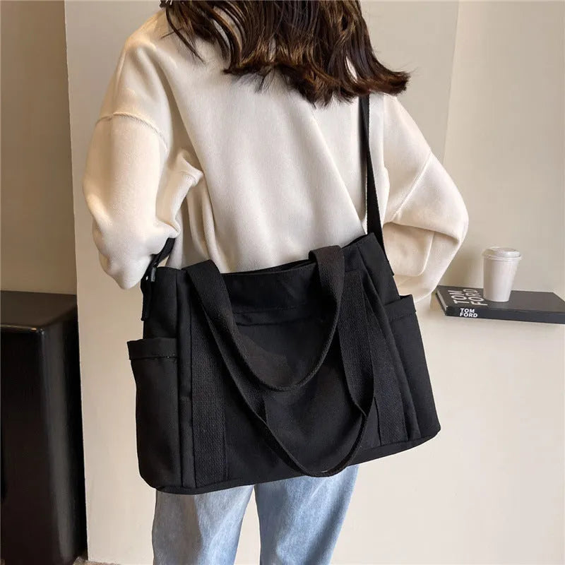 Large capacity polyester canvas shoulder tote bag in a solid colour, showing outer sandwich pocket.