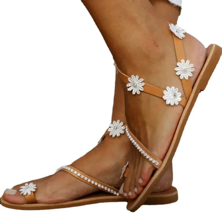 Brown women's floral Roman sandals with flat sole and slip-on design