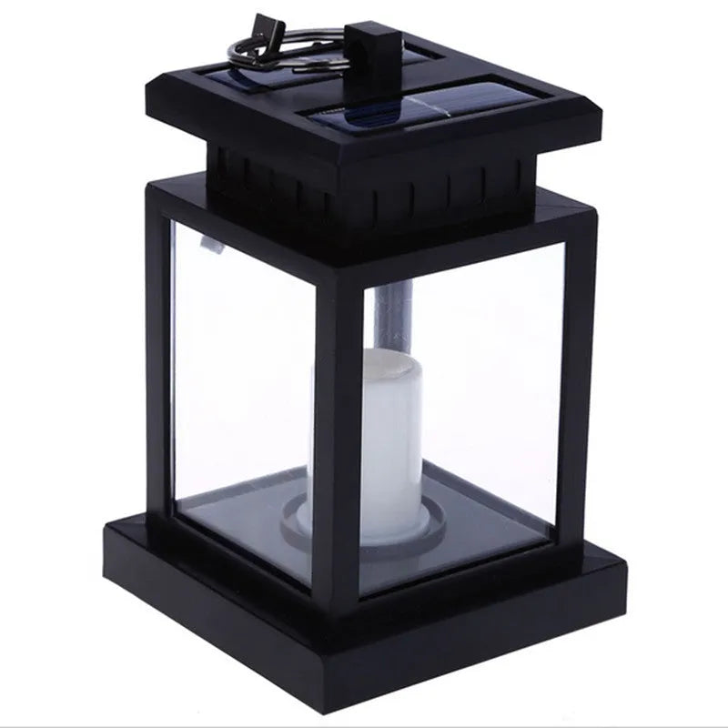 Solar LED candle light with black plastic shade, monocrystalline panel, and warm white illumination on garden path