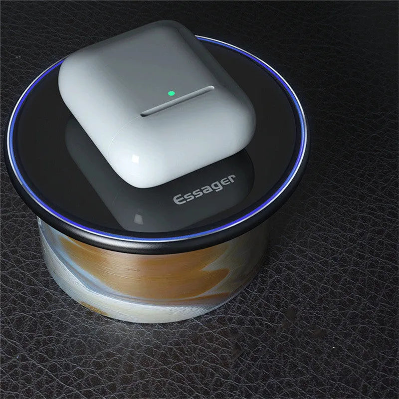 Black Qi wireless charging pad on a desk with blue LED light indicating active charging.