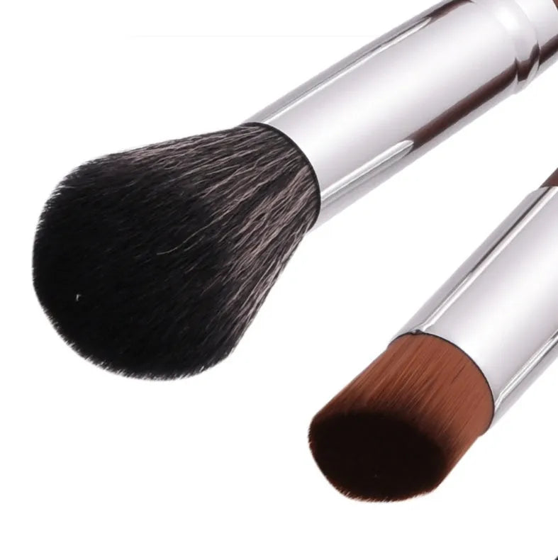 10 brown makeup brushes with wooden handles and nylon bristles laid out on a flat surface