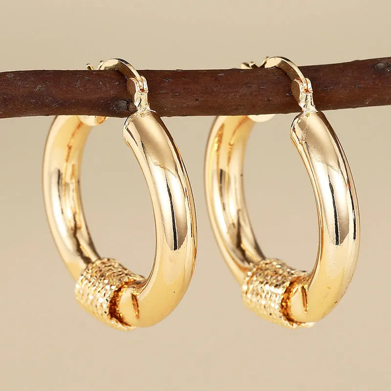 Women's geometric copper earrings with ring and line design in golden colours, ear clip style