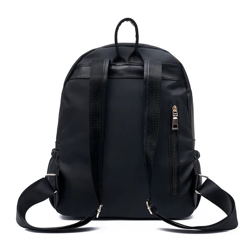 Black waterproof Oxford cloth backpack for women, 34x26x13cm, with two straps and front pocket on plain background