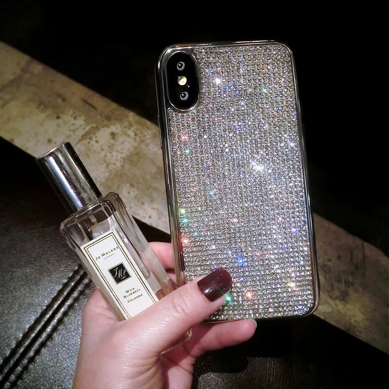 Silver silicone full diamond protective case for iPhone on a table.