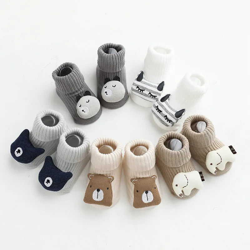 Baby socks with non-slip rubber grip soles on the feet, shown in a light grey colour.