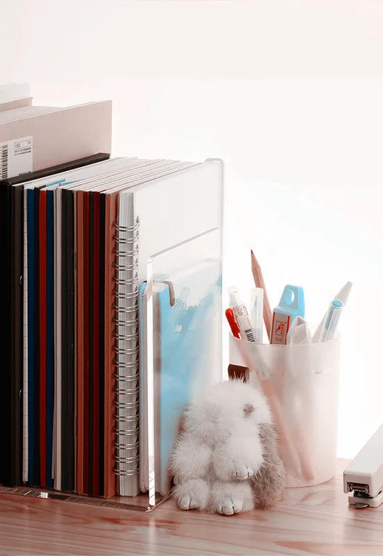 Transparent acrylic bookshelf holding two books on a desk surface