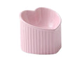 Close-up of a pink ceramic pet bowl with a slanted rim, showing the inclined feeding surface against a clean background.