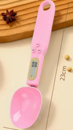 White digital kitchen scale with LCD screen displaying weight, shown next to a measuring spoon.