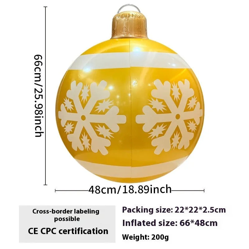 Large red inflatable Christmas ball with flashing lights displayed on a winter garden lawn.