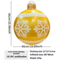 Large red inflatable Christmas ball with flashing lights displayed on a winter garden lawn.