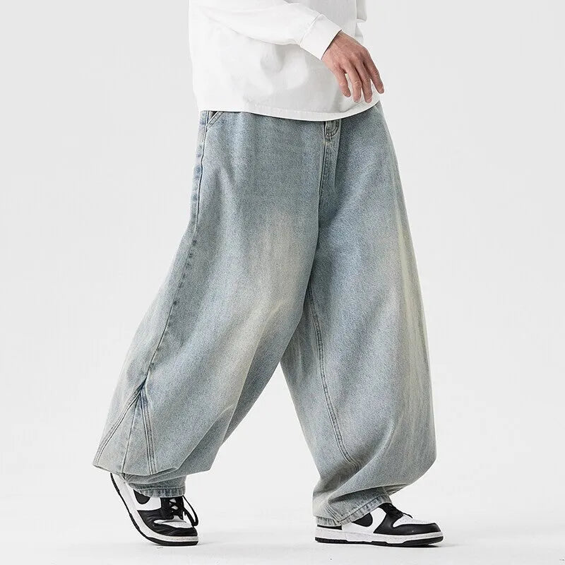 Men's plus-size light blue wide-leg baggy denim jeans on a hanger.