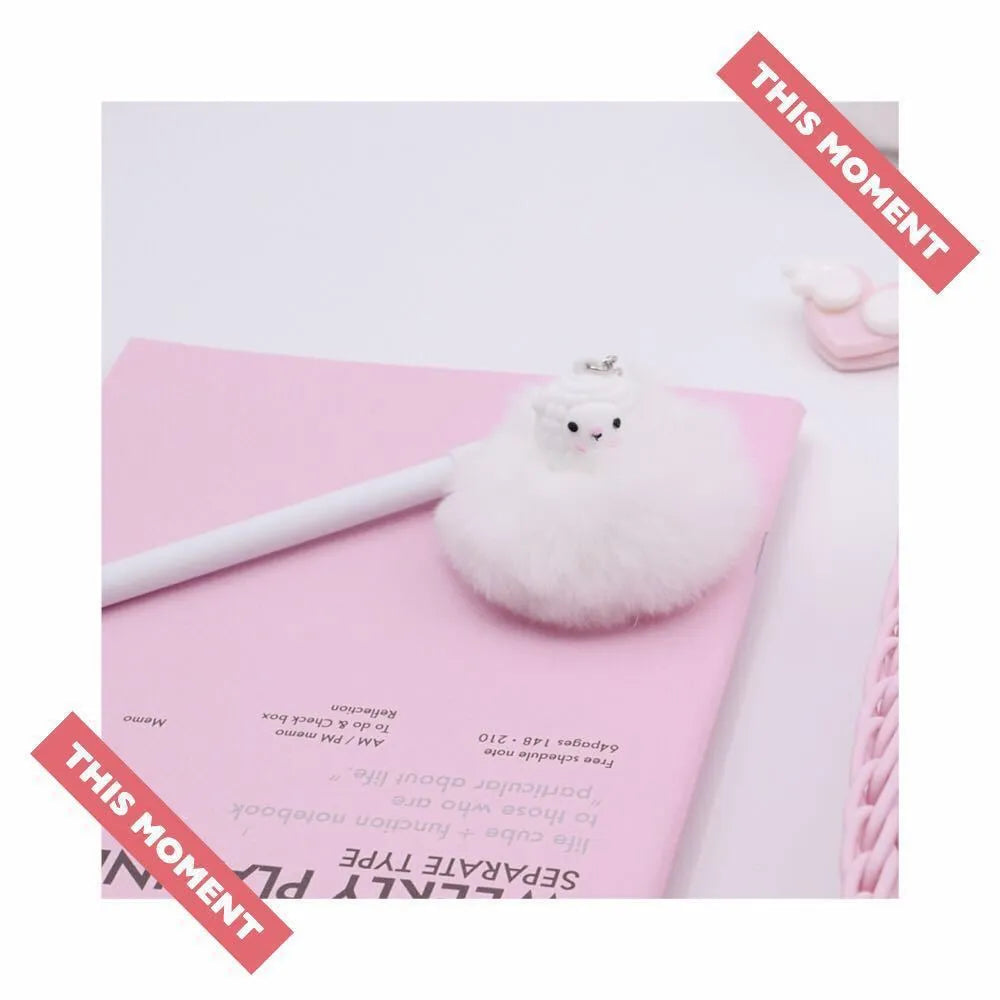 Neutral-coloured plastic ballpoint pen with alpaca hair ball pendant, showing 17cm length and 0.5mm tip.