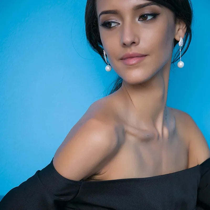 A pair of sterling silver angel wing earrings with diamond cut details and gold-plated gemstone inlay.