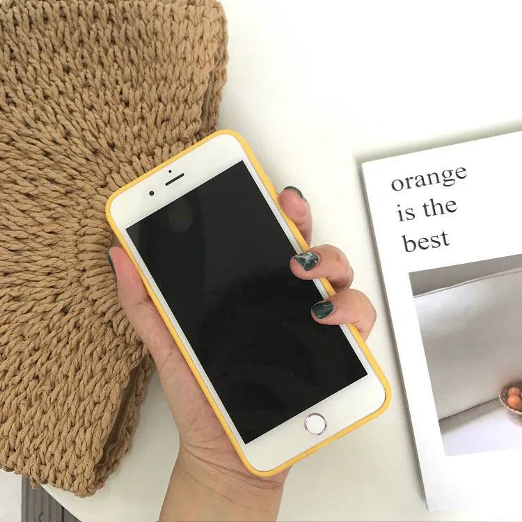 Orange matte finish TPU silicone case for iPhone on a table.